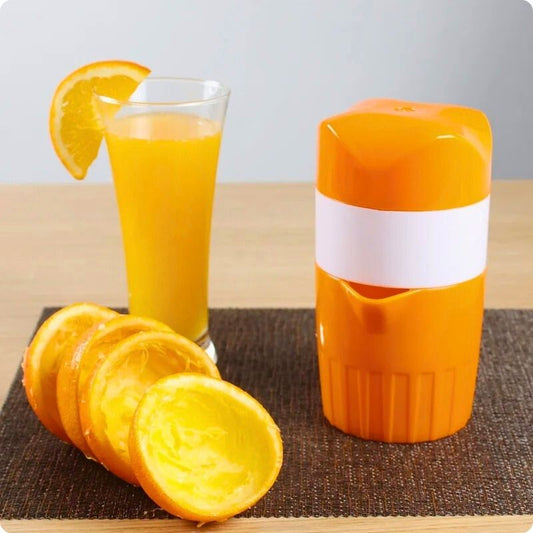 presse agrume manuel rapide pressine posé sur une table à côté peau d'orange