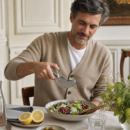 Presse agrume manuel utilisé par un homme qui verse du jus frais sur une salade