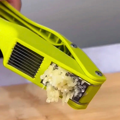Presse ail avec de la purée d'ail qui sort de l'appareil.