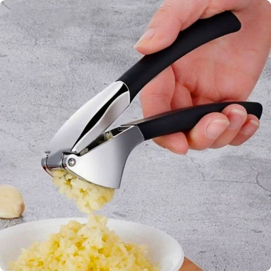 Presse ail tenu par une personne au-dessus assiette purée d'ail
