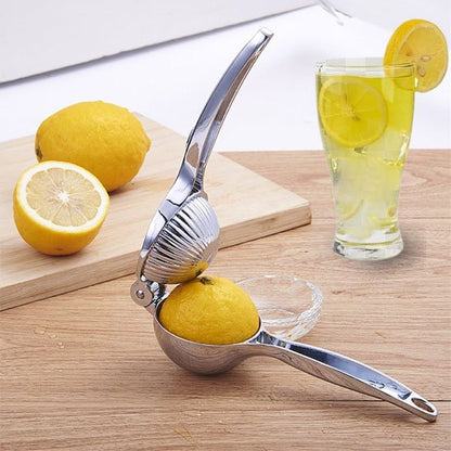 Presse citron manuel posé sur une table en cuisine avec des citrons
