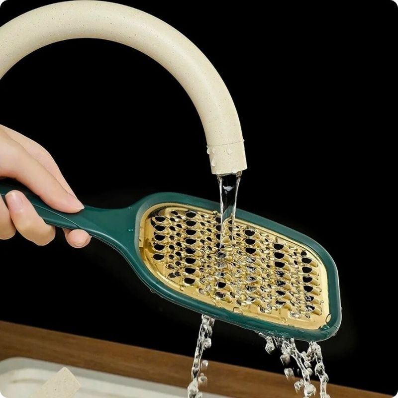 Râpe à carottes passé sous l'eau du robinet.