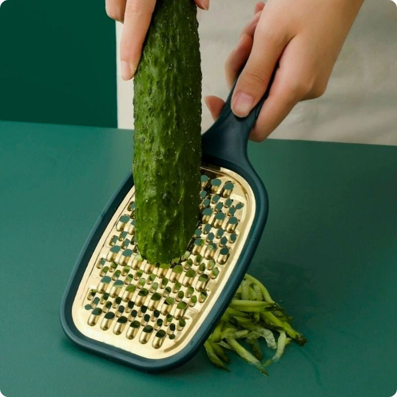 Râpe à carottes utilisée pour râper une concombre.
