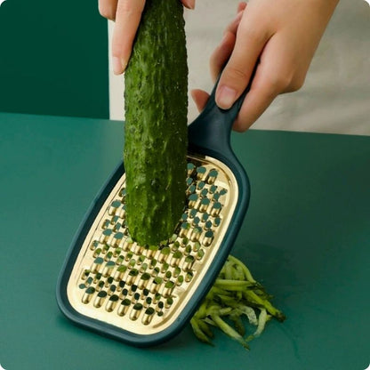 Râpe à carottes utilisée pour râper une concombre.