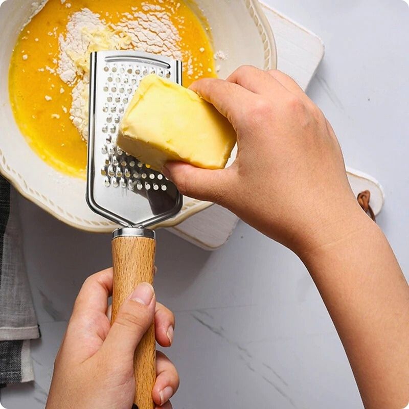 Personne râpant fromage dessus assiette à l'aide d'une rape a fromage