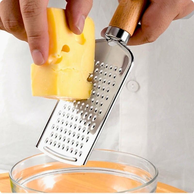 Personne râpant fromage dessus bol à l'aide d'une rape a fromage