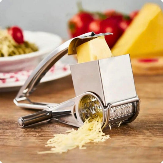 Râpe à fromage posée sur une table avec du fromage râpé que sort du tambour.
