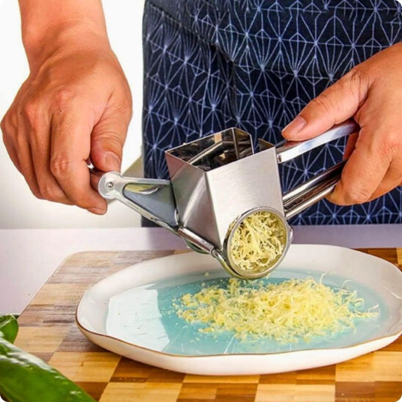 Râpe à fromage utilisée par une personne pour râper du fromage dans une assiette.