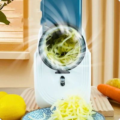 Râpe à légumes électrique posée sur une table avec de l'air circulaire devant les lames rotatives.