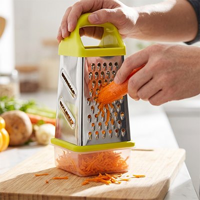 Râpe à légumes manuelle couleur verte utilisée pour râper des carottes