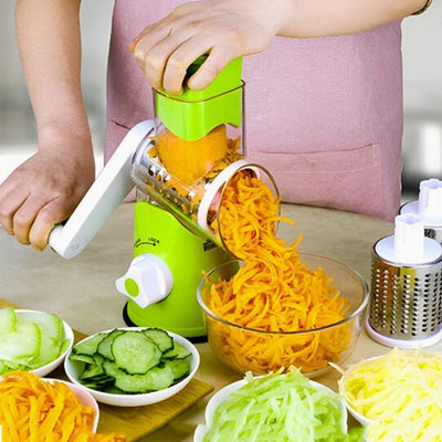 Personne utilisant une râpe à légumes manuelle pour râper des carottes à côté de bols remplis de légumes râpés ou coupés.