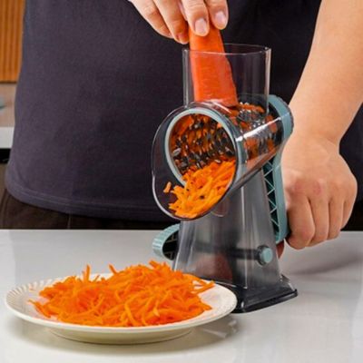Râpe à légumes manuelle râpant une carotte dans une assiette