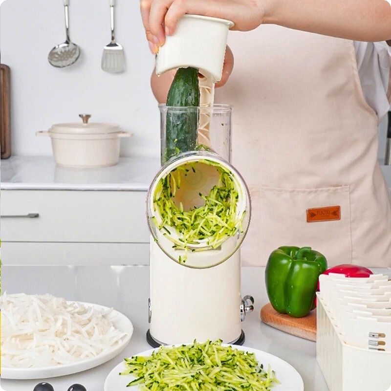 Râpe légumes manuelle utilisée par une personne pour râper une courgette.