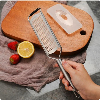 râpe manuelle tenue par une main au dessus d'une planche