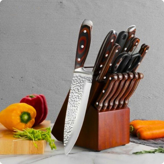 Set de couteaux de cuisine éclat du chef sur la table à côté de poivrons.