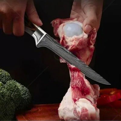 Personne désossant un os avec un couteau du set de couteau de cuisine